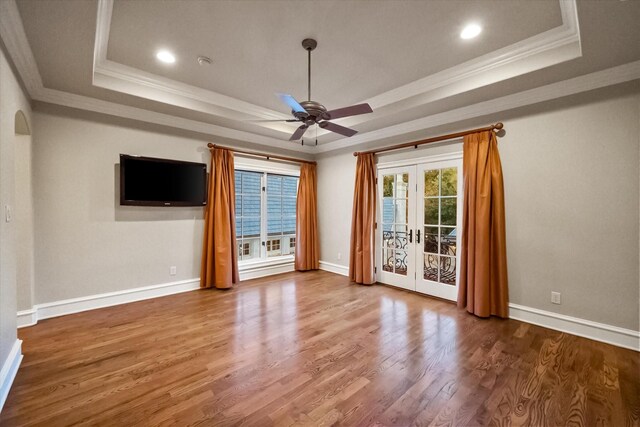 unfurnished room with baseboards, a raised ceiling, wood finished floors, and french doors