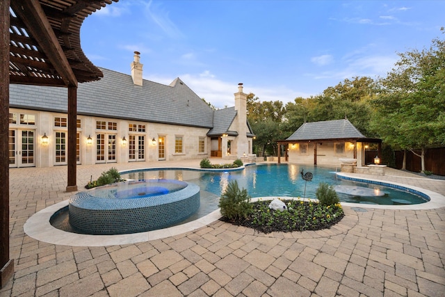 view of pool featuring french doors, a patio, fence, an outdoor structure, and a storage structure