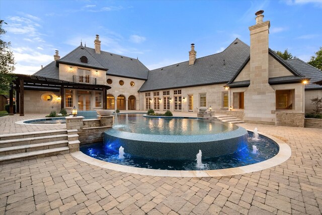 pool featuring an in ground hot tub, a patio, and a pergola