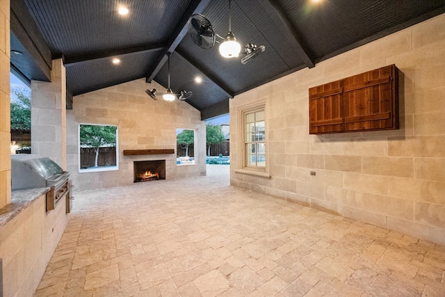 view of patio / terrace featuring exterior kitchen, a warm lit fireplace, a grill, and ceiling fan