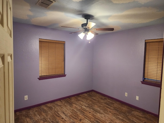 unfurnished room featuring ceiling fan and dark hardwood / wood-style floors