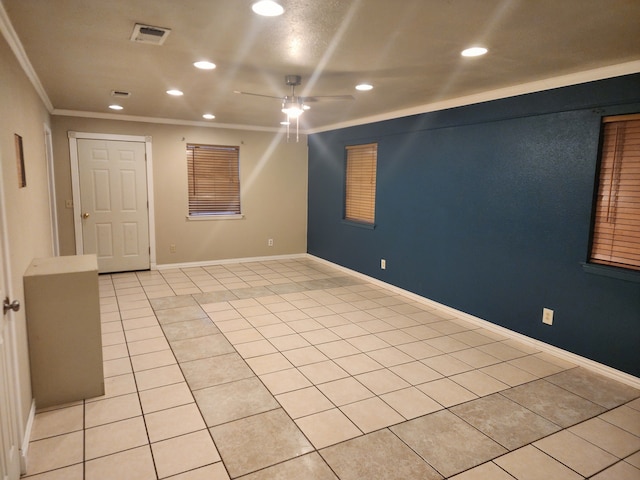 empty room with light tile patterned floors, crown molding, and ceiling fan