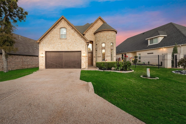 french country inspired facade featuring a lawn and a garage