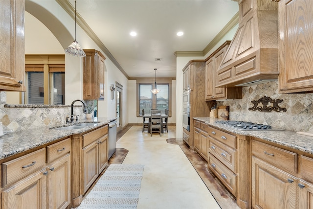 kitchen featuring light stone counters, sink, pendant lighting, and stainless steel appliances