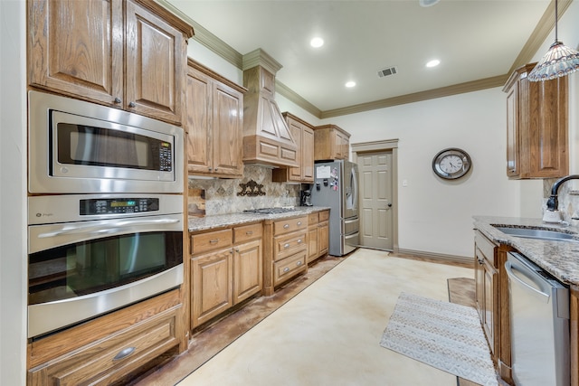 kitchen featuring appliances with stainless steel finishes, sink, light stone counters, and ornamental molding