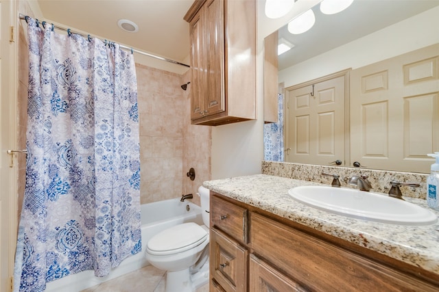 bathroom with toilet, vanity, and tile patterned flooring