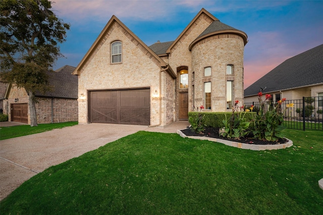 french country inspired facade featuring a lawn and a garage