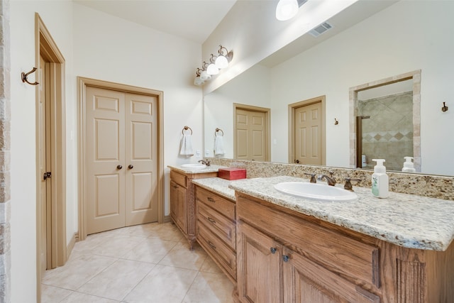 bathroom featuring vanity, tile patterned flooring, and a tile shower