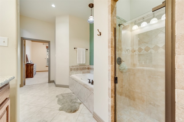 bathroom featuring tile patterned flooring, vanity, and shower with separate bathtub