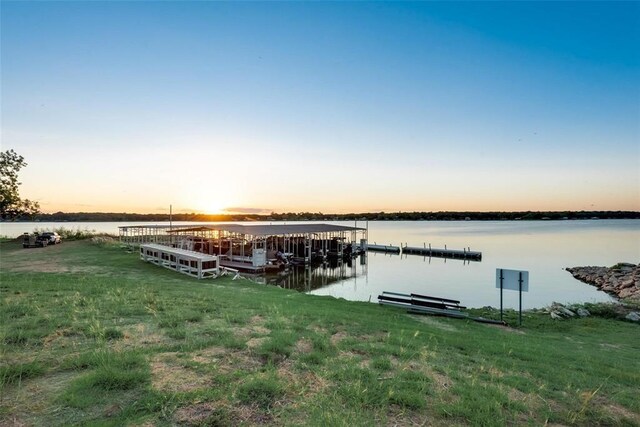 dock area with a water view and a lawn