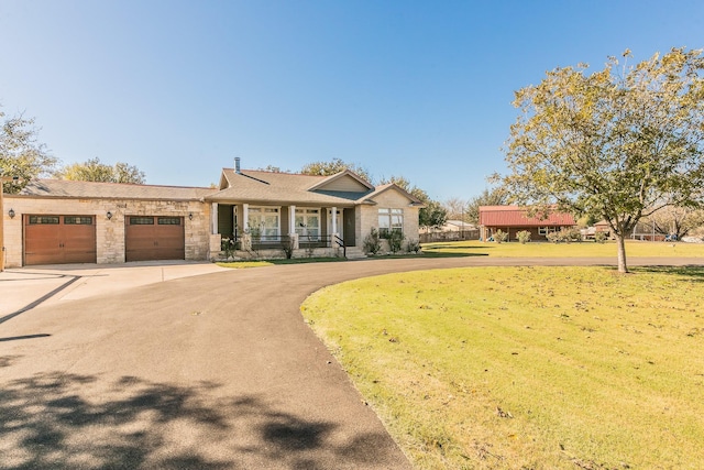 view of front of property with a porch, a garage, and a front lawn