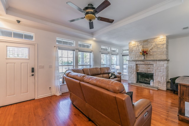 living room featuring hardwood / wood-style flooring, a raised ceiling, plenty of natural light, and ornamental molding