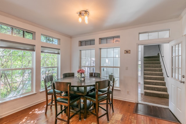 dining room with wood-type flooring and ornamental molding