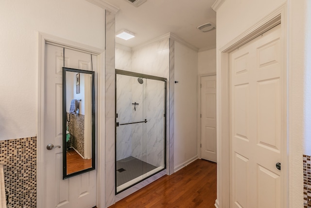 bathroom with crown molding, hardwood / wood-style floors, and an enclosed shower