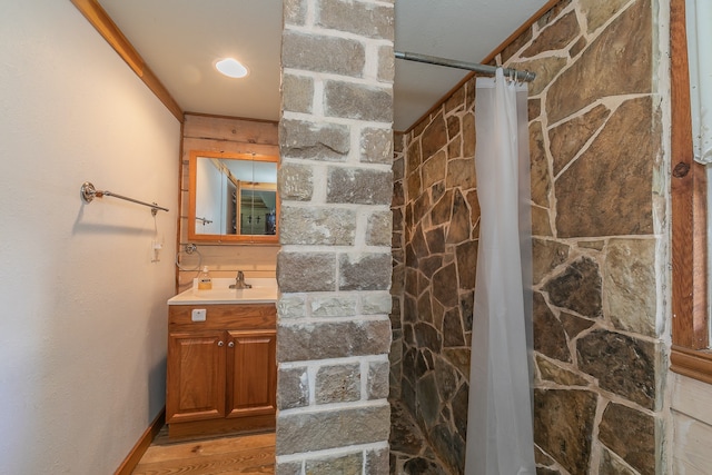 bathroom with wood-type flooring, vanity, walk in shower, and crown molding