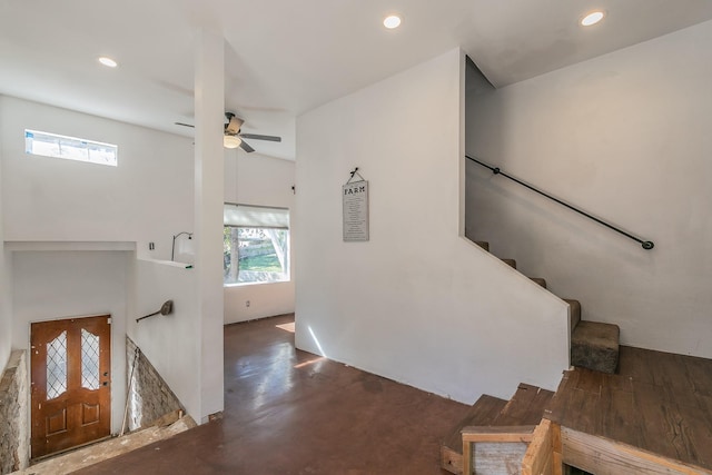 staircase with concrete floors and ceiling fan