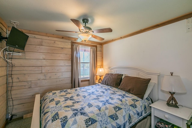 bedroom with ceiling fan and wooden walls