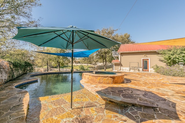 view of swimming pool featuring an in ground hot tub, a patio, and an outbuilding