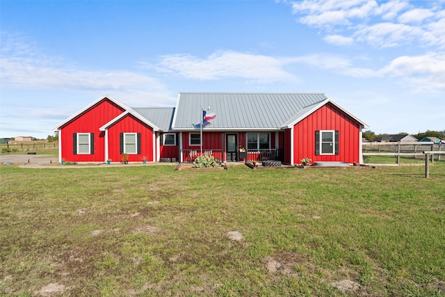 ranch-style home featuring covered porch and a front yard