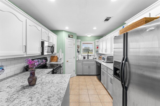 kitchen with backsplash, black appliances, light tile patterned floors, gray cabinets, and white cabinetry