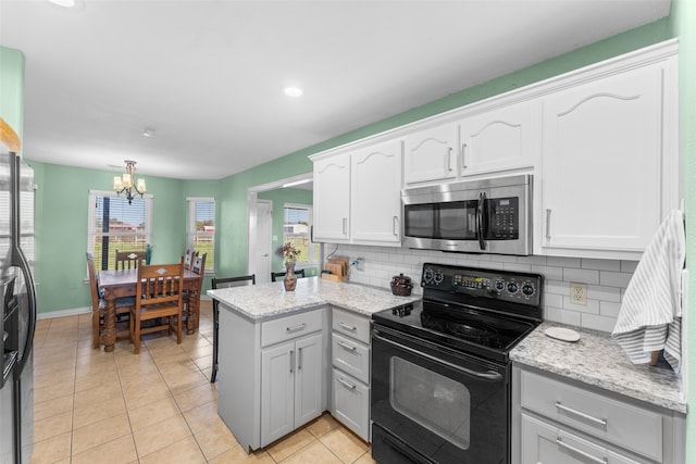 kitchen with backsplash, an inviting chandelier, white cabinets, light stone countertops, and stainless steel appliances