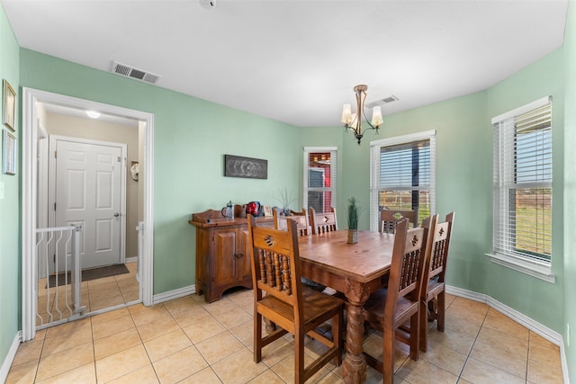 tiled dining room featuring an inviting chandelier