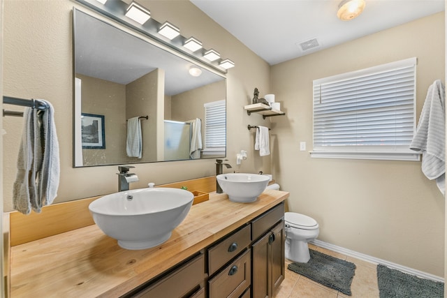 bathroom with tile patterned floors, vanity, toilet, and a shower with shower door