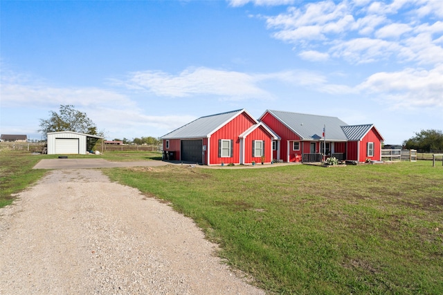 view of front of home featuring a garage, an outdoor structure, and a front lawn