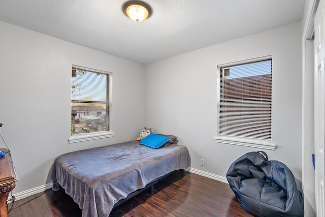 bedroom with dark hardwood / wood-style flooring