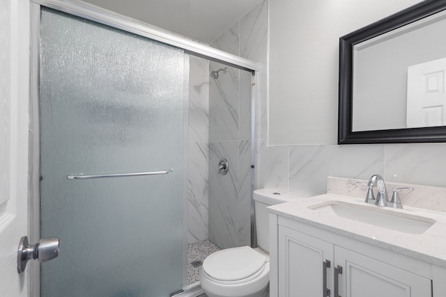 bathroom with vanity, toilet, walk in shower, tile walls, and tasteful backsplash