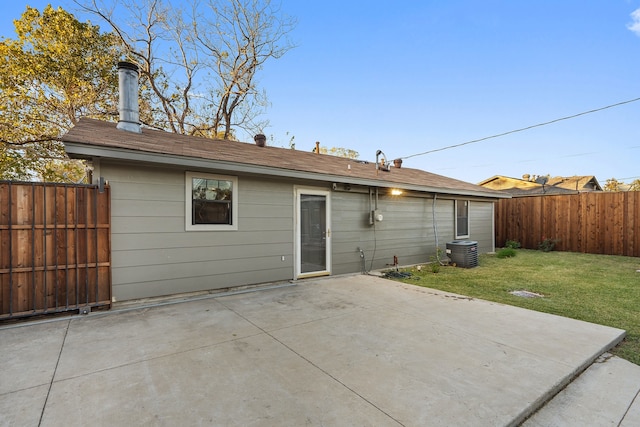 rear view of property featuring a lawn, a patio area, and central AC