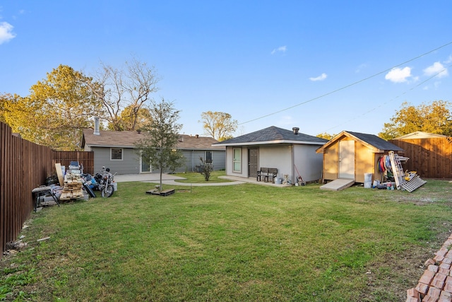 back of property with a patio area, a yard, and a storage shed