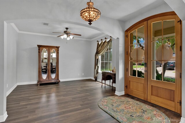 entrance foyer featuring ceiling fan with notable chandelier, dark hardwood / wood-style floors, and crown molding