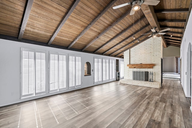 unfurnished living room with beam ceiling, wooden ceiling, a fireplace, and high vaulted ceiling