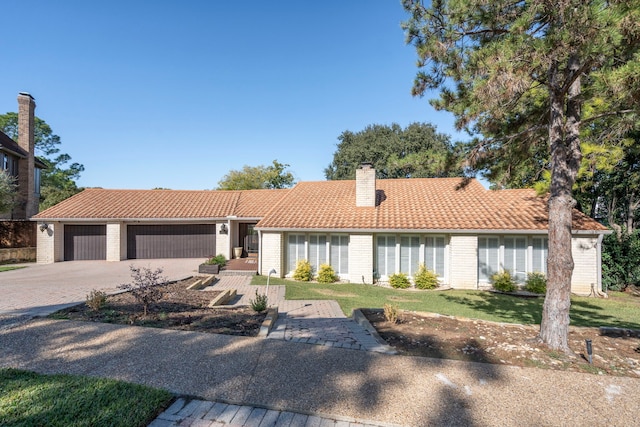 view of front of house featuring a garage and a front lawn