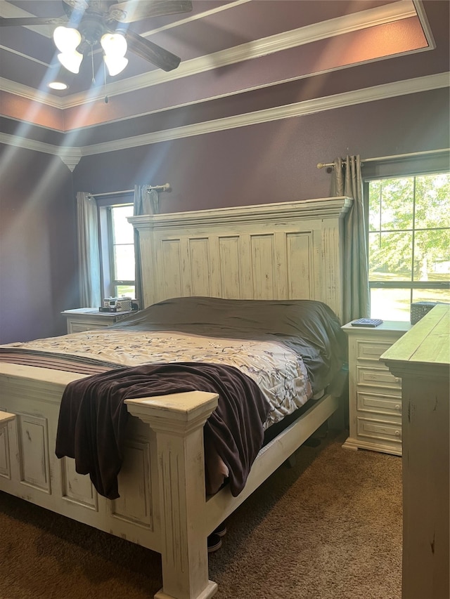 bedroom featuring dark carpet, multiple windows, ornamental molding, and ceiling fan