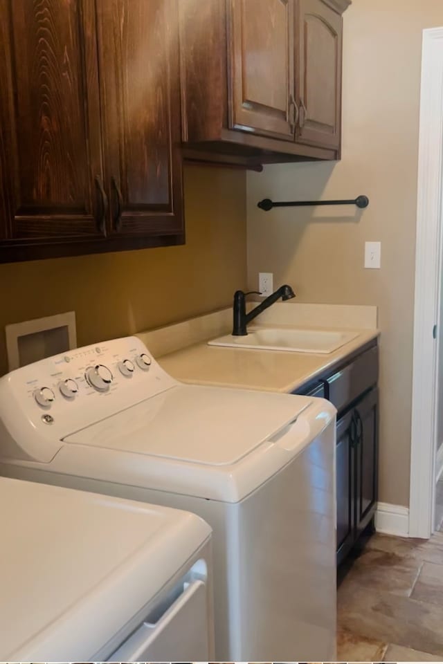 laundry room with cabinets, washing machine and dryer, and sink