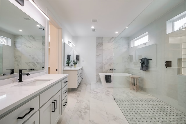 bathroom with a bathtub, vanity, and a healthy amount of sunlight