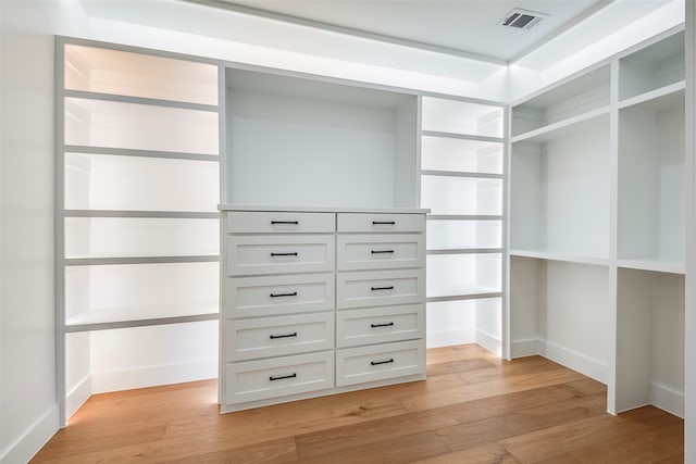 walk in closet with light hardwood / wood-style flooring