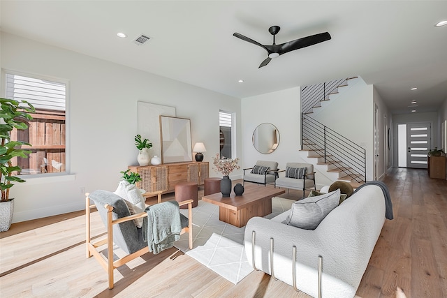 living room featuring light wood-type flooring and ceiling fan