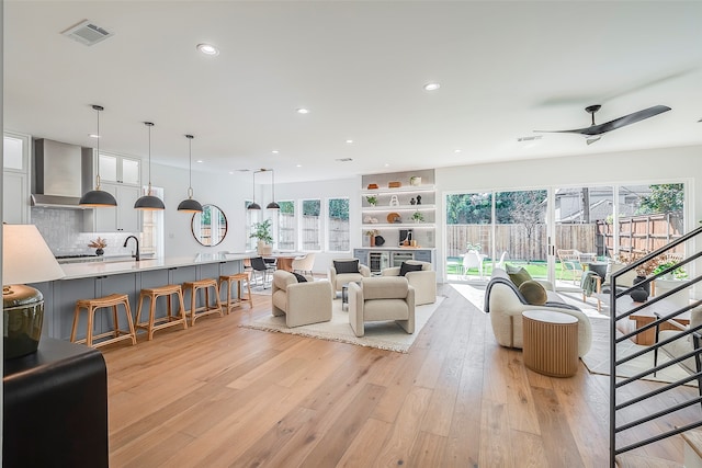 living room with light hardwood / wood-style floors, a wealth of natural light, and ceiling fan