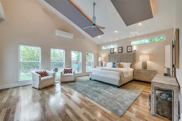 bedroom featuring high vaulted ceiling, a wall unit AC, and light hardwood / wood-style floors