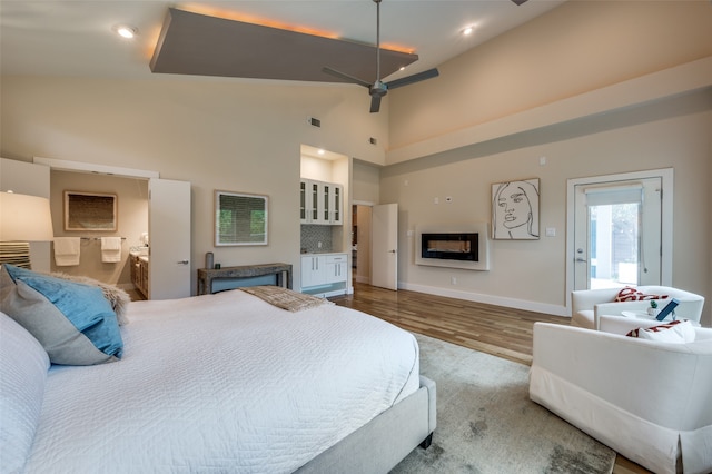 bedroom with a towering ceiling and hardwood / wood-style floors