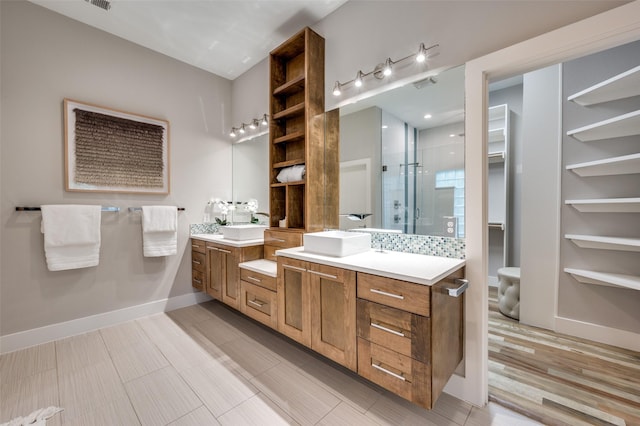 bathroom featuring hardwood / wood-style flooring, vanity, and a shower