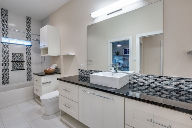 full bathroom featuring toilet, tiled shower / bath, vanity, tile patterned flooring, and decorative backsplash