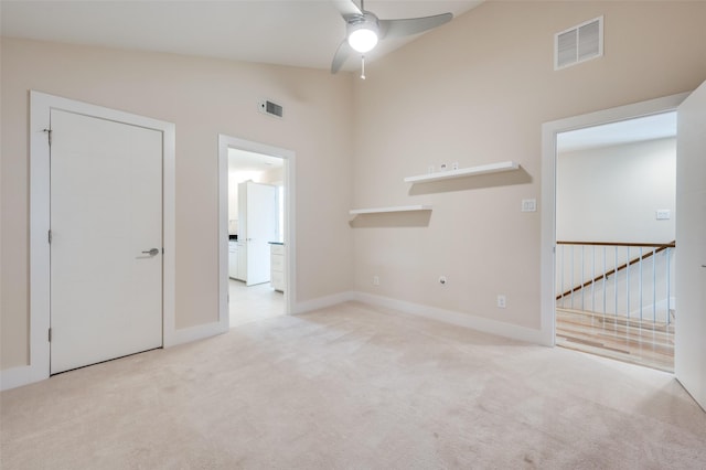 carpeted spare room with vaulted ceiling and ceiling fan