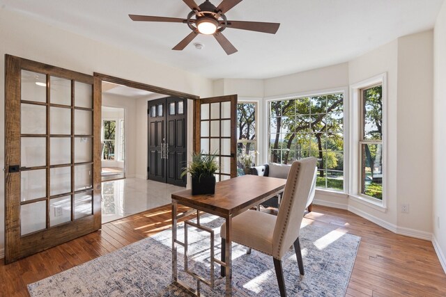 office featuring hardwood / wood-style flooring, ceiling fan, a healthy amount of sunlight, and french doors