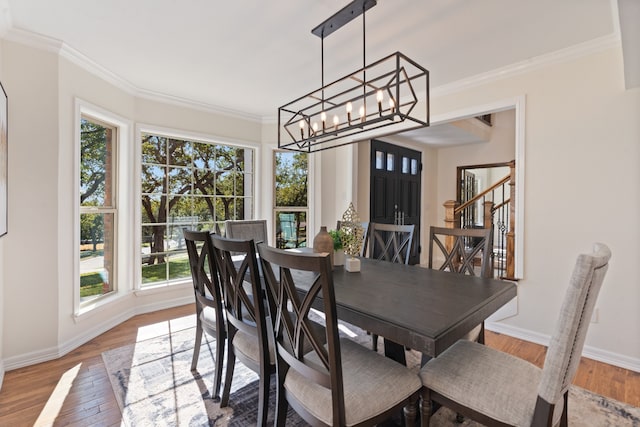 dining space with crown molding, a healthy amount of sunlight, and wood-type flooring