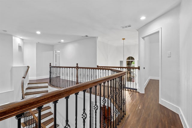 hall with dark wood-type flooring and a notable chandelier