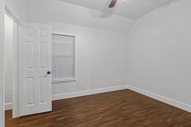 spare room featuring dark hardwood / wood-style floors, vaulted ceiling, and ceiling fan